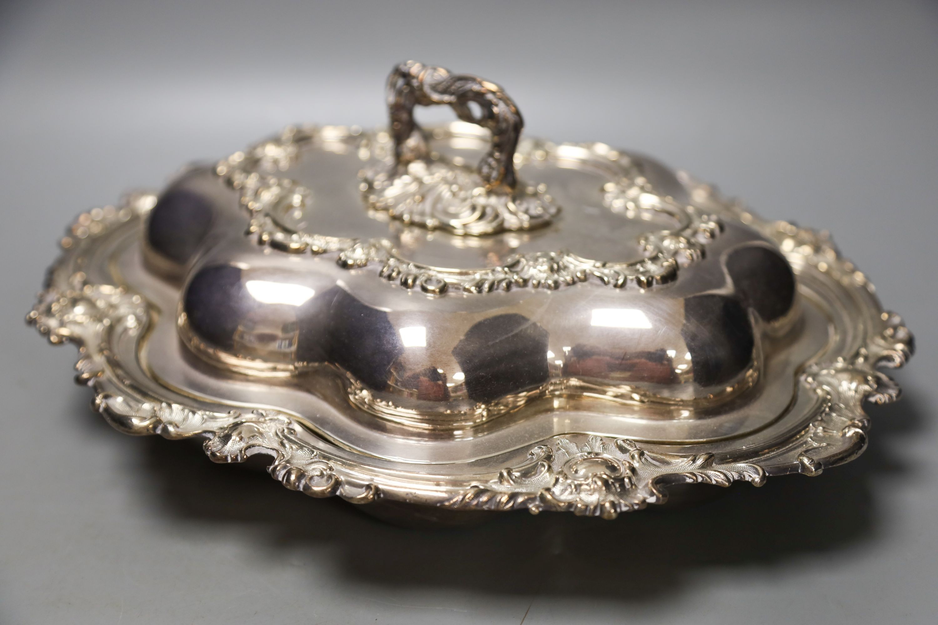 A pair of cast plated shaped oval entree dishes and covers and pair of linked cast plated breakfast braziers and covers, with turned wood handles